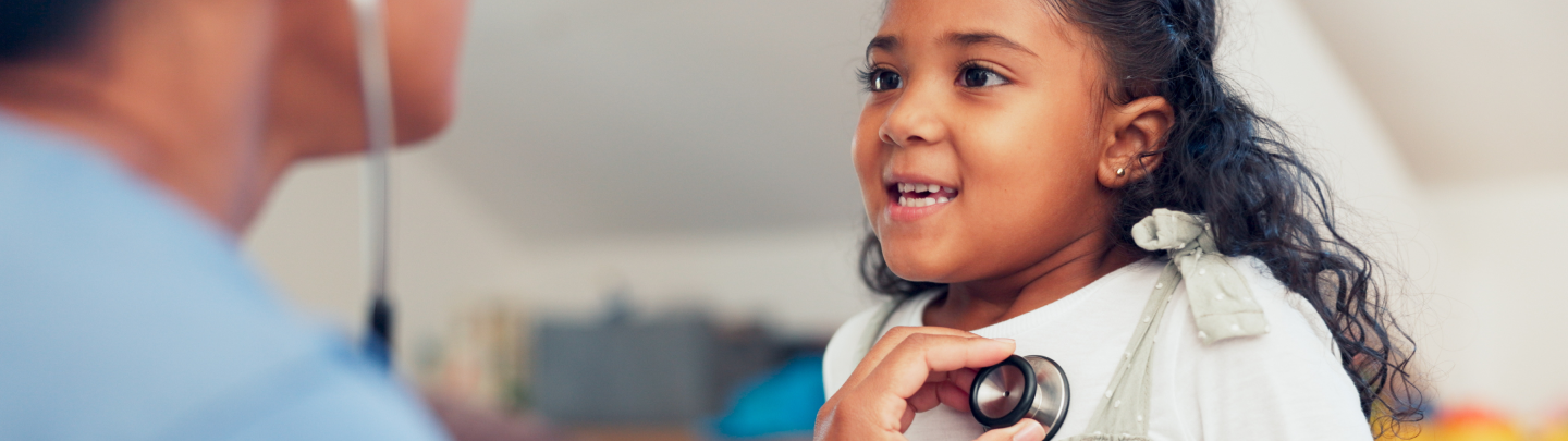 young boy in a wheelchair smiling while being read a book